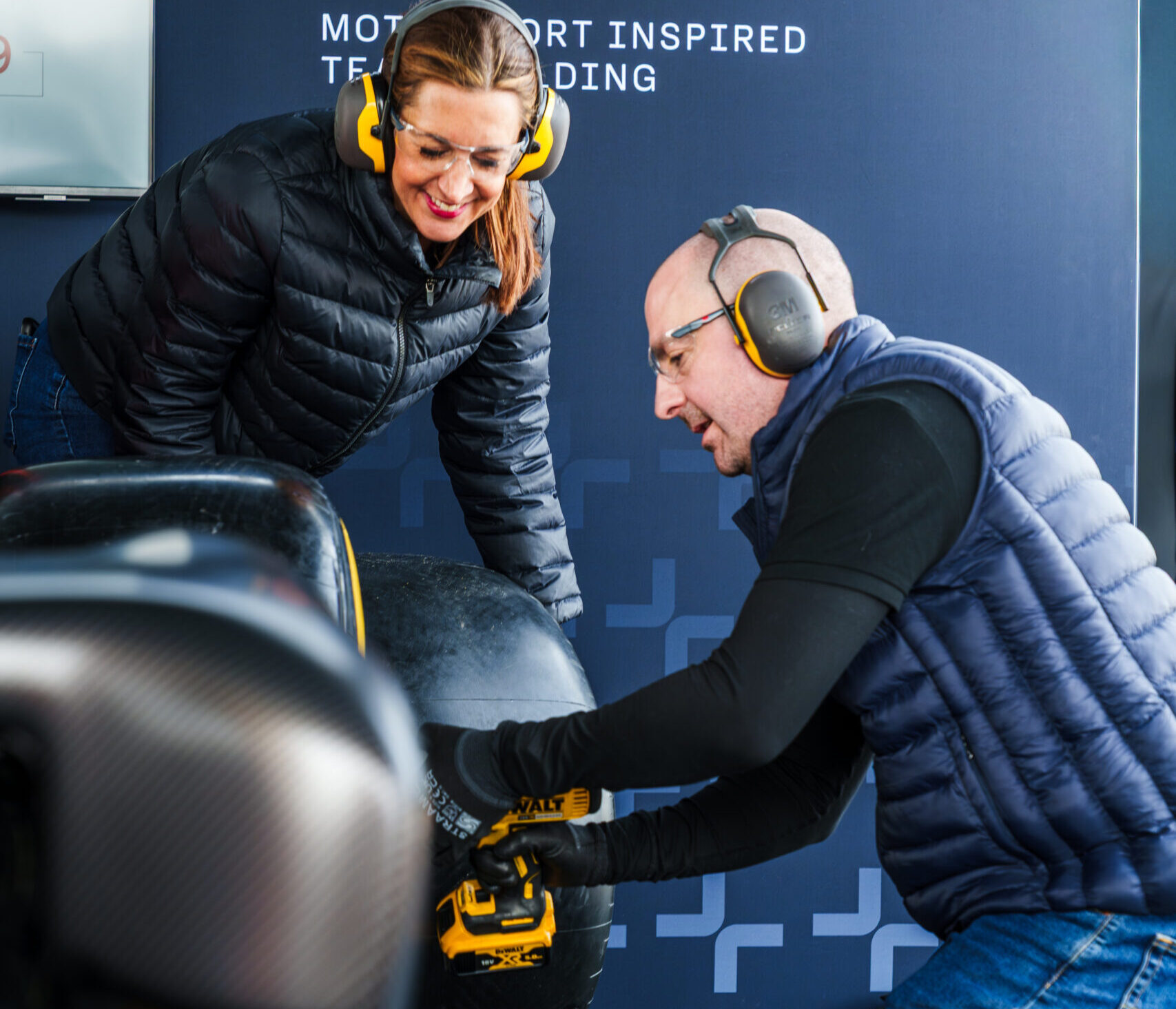 Corporate team completing pit stop challenge during r.a.c.e motorsport team building event