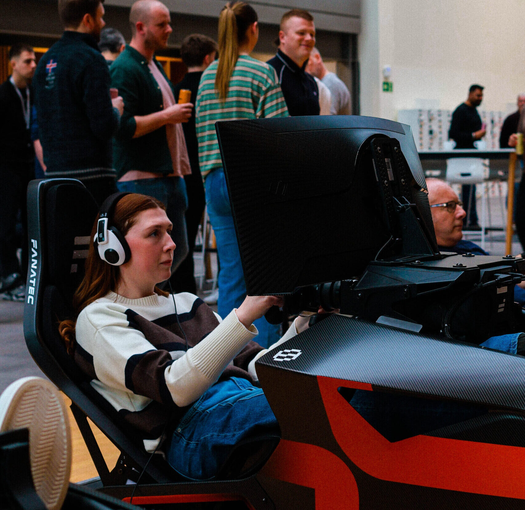 Corporate team completing racing simulator challenge during r.a.c.e motorsport team building event