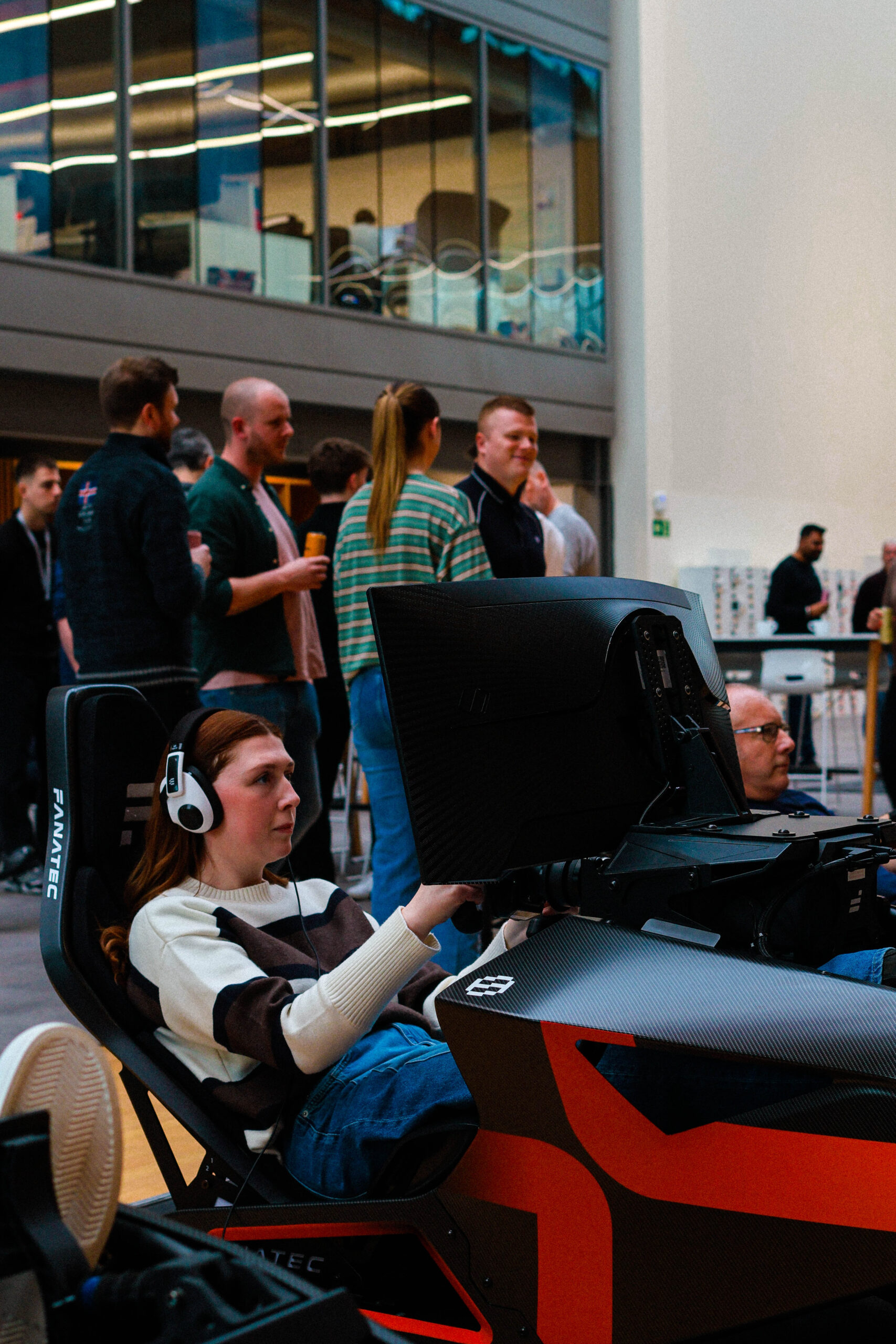 Corporate team completing racing simulator challenge during r.a.c.e motorsport team building event